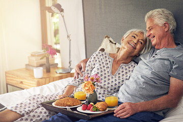 I brought you some breakfast. Shot of a senior couple having breakfast in bed.