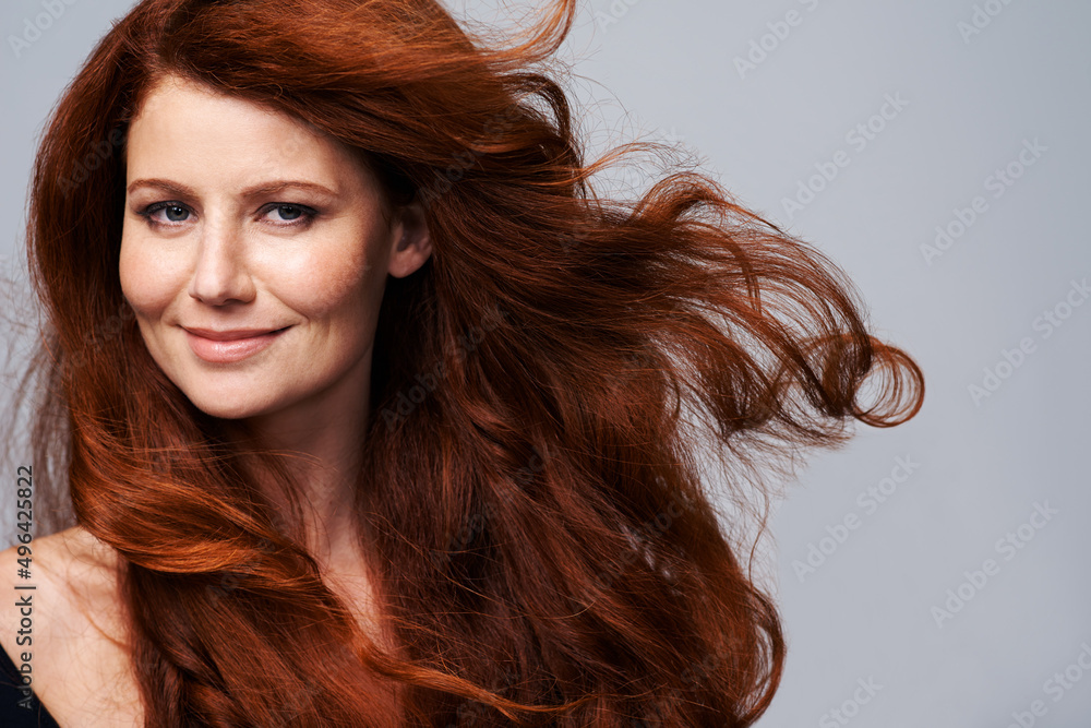 Canvas Prints Showing off her crowning glory. Studio shot of a young woman with beautiful red hair posing against a gray background.