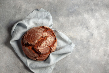 artisan dark unleavened bread searved on gray stone background with blue linen napkin
