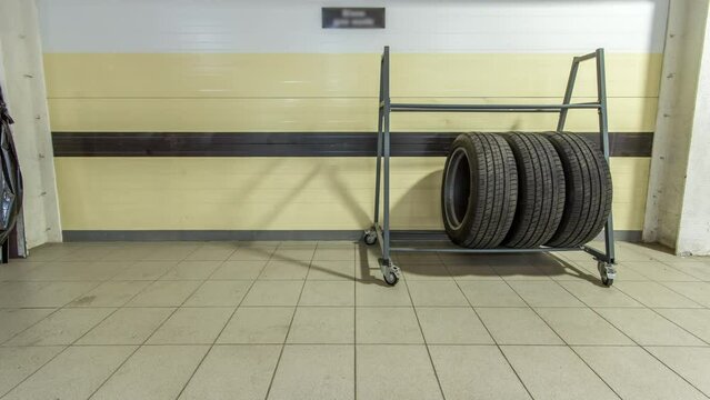 Car mechanic put tires from trolley to rack in auto repair service timelapse.