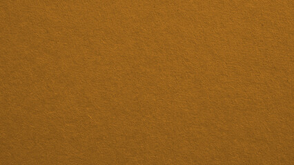 The surface of bright brown cardboard. Paperboard wallpaper. Textured pasteboard background. Paper texture with cellulose fibers. Macro