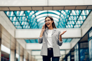 Fototapeta premium A businesswoman at the business center receiving a good news on the phone.