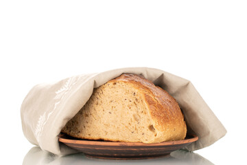 One half of buckwheat fragrant bread with a linen napkin on a clay plate, macro, isolated on a white background.
