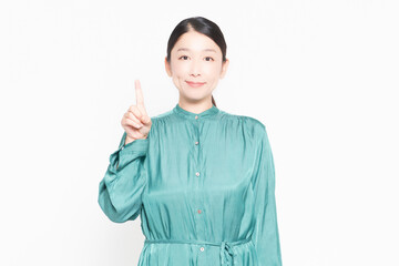 白い背景の前に立っているポイントを示す主婦