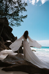 Fototapeta na wymiar Beautiful young woman bride in a long white wedding dress on the Seychelles beach on the island of Mahe or La Digue