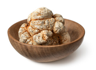 Dried notoginseng roots in the wooden bowl, isolated on the white background.
