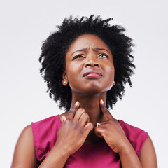 I wonder what could be causing me this much pain. Studio shot of a young woman suffering with a sore throat against a grey background.