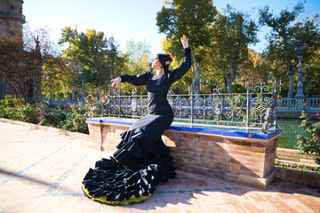 Flamenco dancer woman, brunette and beautiful dressed in typical black costume with yellow polka...