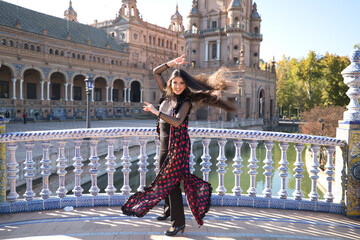 Young and beautiful typical Spanish woman dancing flamenco with urban and modern clothes, wearing...