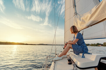 Luxury travel on the yacht. Young happy woman on boat deck sailing the river.