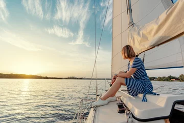 Fototapeten Luxury travel on the yacht. Young happy woman on boat deck sailing the river. © luengo_ua
