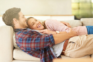 We fit together perfectly. Shot of a happy young couple relaxing on the sofa at home.