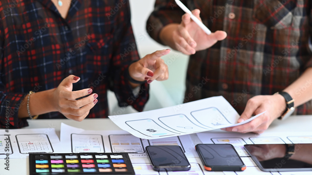 Poster cropped shot of designers creating mobile application prototype at office desk.
