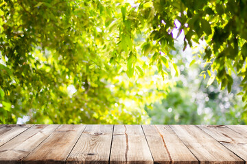 Empty wooden table with garden bokeh for a catering or food background with a country outdoor theme,Template mock up for display of product