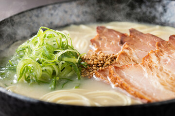 湯気が上がる、シズル感のある豚骨ラーメン