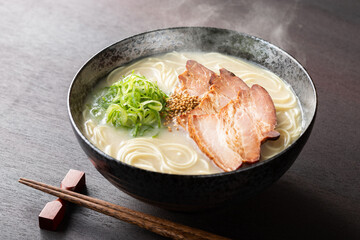 湯気が上がる、シズル感のある豚骨ラーメン