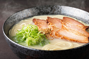 湯気が上がる、シズル感のある豚骨ラーメン