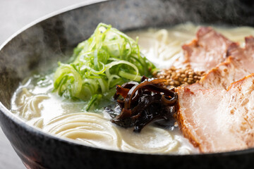 湯気が上がる、シズル感のある豚骨ラーメン
