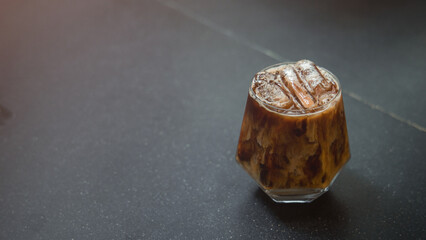 Ice coffee on table with cream being poured into it showing the texture and refreshing look of the drink