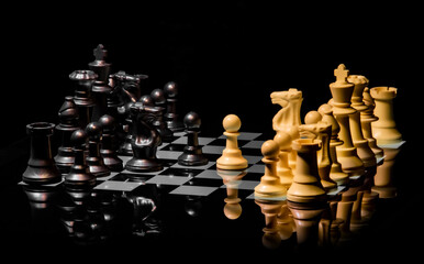 Close up of Chess pieces on a reflective mirror board surface with black background