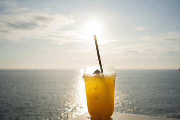 Orange juice on table seaside during sunset sky. 
