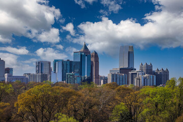 glass skyscrapers and office buildings in the cityscape with miles of lush green and autumn colored...