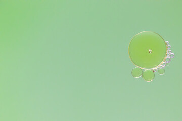 water bubbles flowing liquid with green backdrop perfect to use as backgrounds..