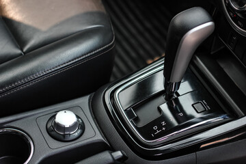 Obraz na płótnie Canvas automatic transmission shift selector in the car interior. Closeup a manual shift of modern car gear shifter. 4x4 gear shift
