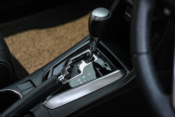 Fototapeta na wymiar automatic transmission shift selector in the car interior. Closeup a manual shift of modern car gear shifter. 4x4 gear shift