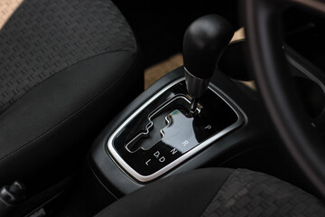 Plakat automatic transmission shift selector in the car interior. Closeup a manual shift of modern car gear shifter. 4x4 gear shift