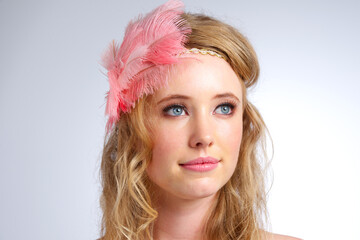 Delicate beauty. Studio shot of a beautiful young woman wearing a feathered headband.