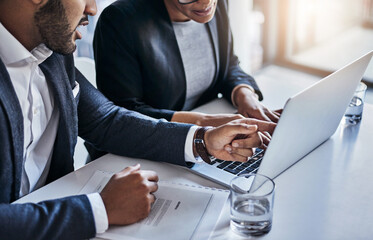 Technology improves the quality of their work. Shot of two businesspeople working together on a...