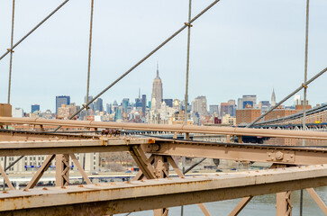 Fototapeta premium Manhattan Bridge with brown steel construction of Brooklyn Bridge in forefront, New York City, Empire State Building in the Background, horizontal