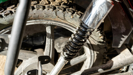 dirty motorcycle front wheel shock absorber, close up of a wheel