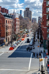 Chelsea City Street crossroads, aerial view from the High Line Rooftop Park, New York City during sunny winter day, lots of cars parked on the street vertical