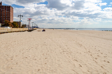 Beach at Coney island with red Parachute Jump and residential Buildings in the Background,...