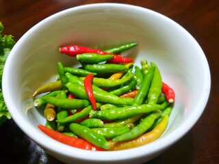 Top view of green and red pepper or chili in white bowl as a background for sale in the market at...
