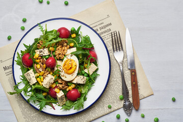 Green salad with tofu and chia seeds. Mixed salad with tofu hazelnuts and tofu on rustic table. Fresh diet salad served in plate.