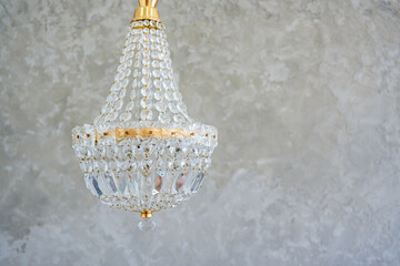 ceiling lamp in classic style with crystal pendants on the background of gray plaster on the wall. copy space. retro interior and decor elements.