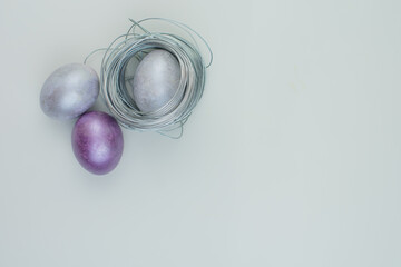 Fototapeta premium silver and lilac easter eggs on a gray flat isolated background for text