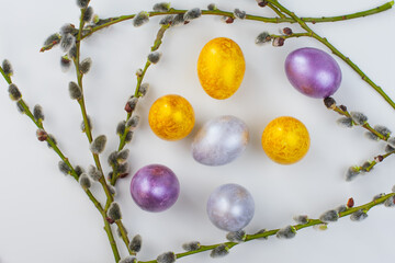 Flat lay easter composition with willow branch and painted eggs on white background