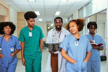Group of medical students walking in a hallway at medical university. Focus is on African American...