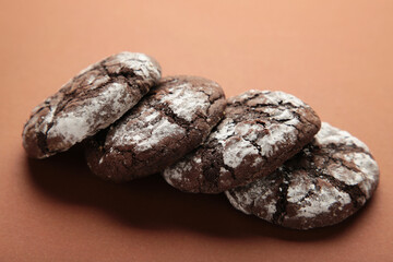 Soft dark chocolate brownie cookies on brown background.