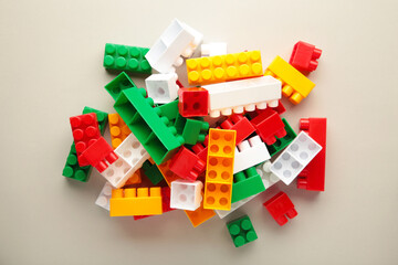 Multicolored blocks of the children's constructor lie on grey background.