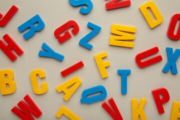 Magnetic plastic alphabet letters on grey background.