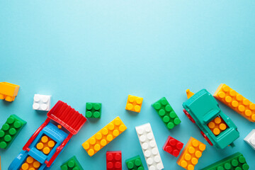 Multicolored blocks of the children's constructor lie on blue background.