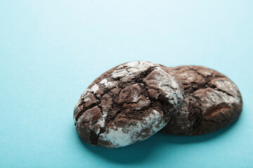 Soft dark chocolate brownie cookies on blue background.
