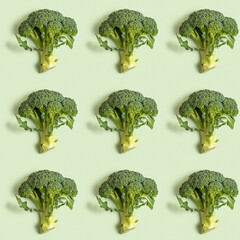 Seamless pattern with fresh broccoli on green background.