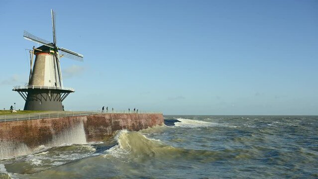Windmill by sea during storm called Franklin, Vlissingen, Netherlands