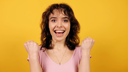 Close up cheerful surprised girl. Wow facial expression. Good news. Attractive young girl on yellow background.